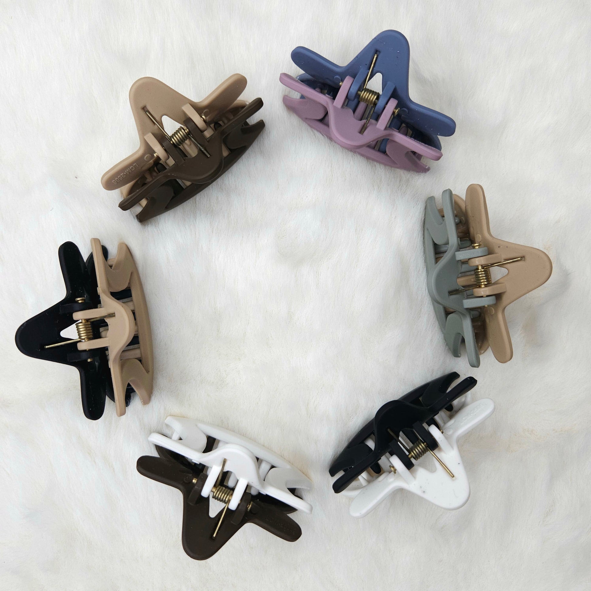 Set of eight hair clips in various colors on a white background shown from top angle