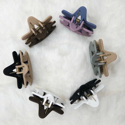 Set of eight hair clips in various colors on a white background shown from top angle