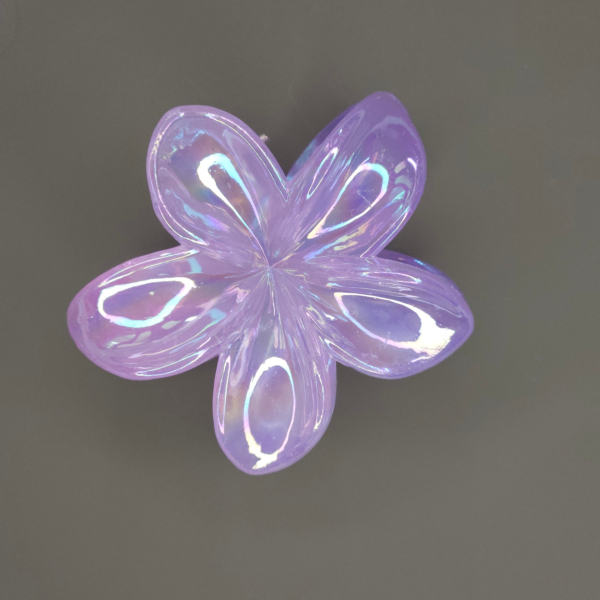 A medium-sized flower hair claw clip in a luminous lavender shade, featuring a dual-shade glimmer finish that appears to shift between purple and soft blue or pink.