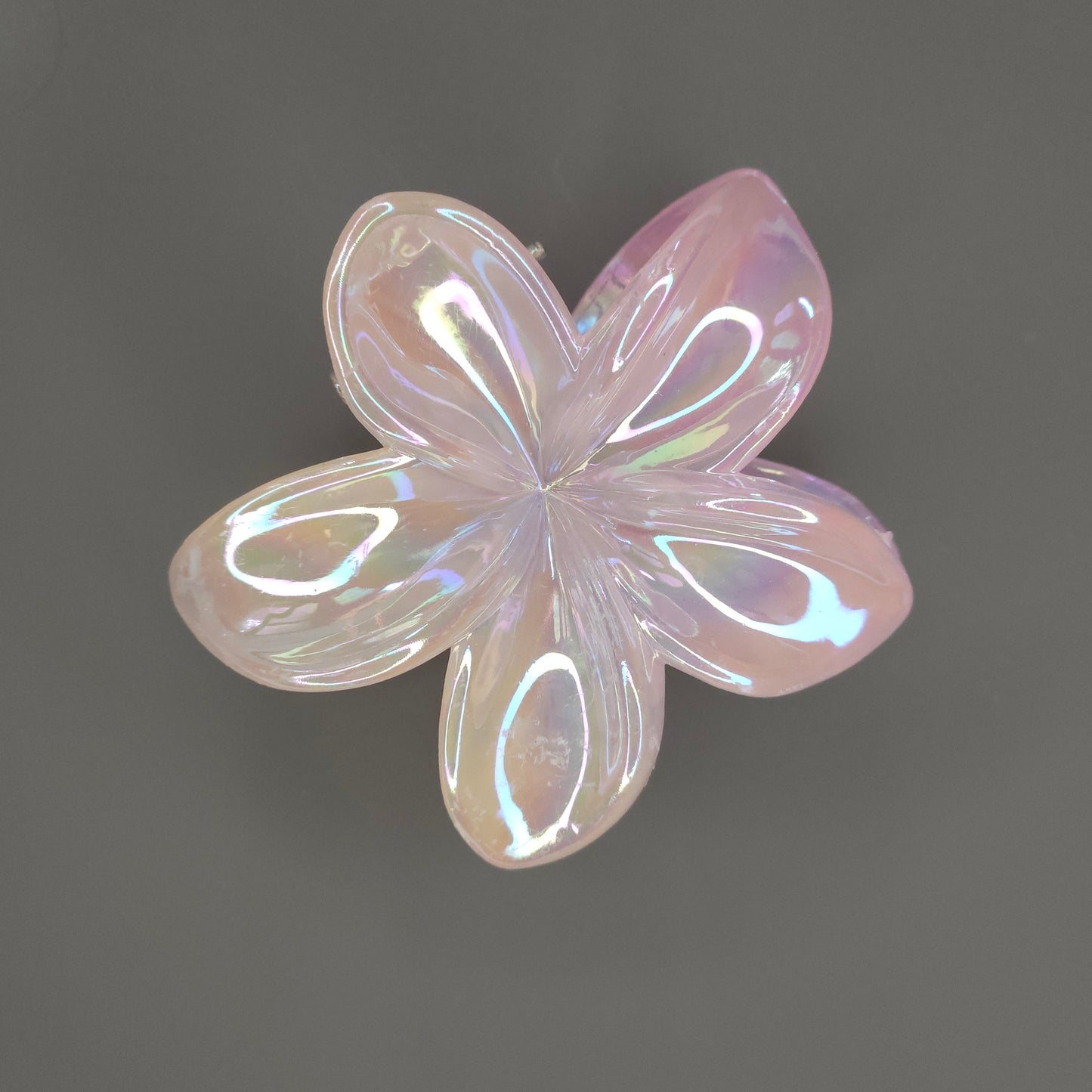 A medium-sized, layered flower hair claw clip in a vibrant orange shade, featuring a glossy dual-shade glimmer finish that subtly shifts between orange and gold or deep coral.