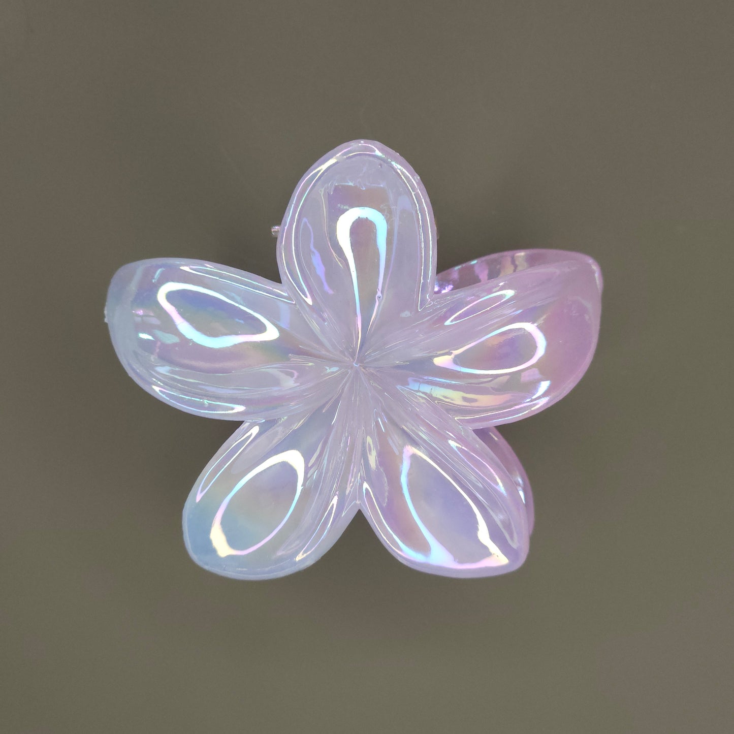 A medium-sized, flower-shaped hair claw clip made of a white material with a 'dual shade glimmer' finish, creating subtle iridescent shifts or a pearlescent effect, possibly hinting at soft pastel undertones.