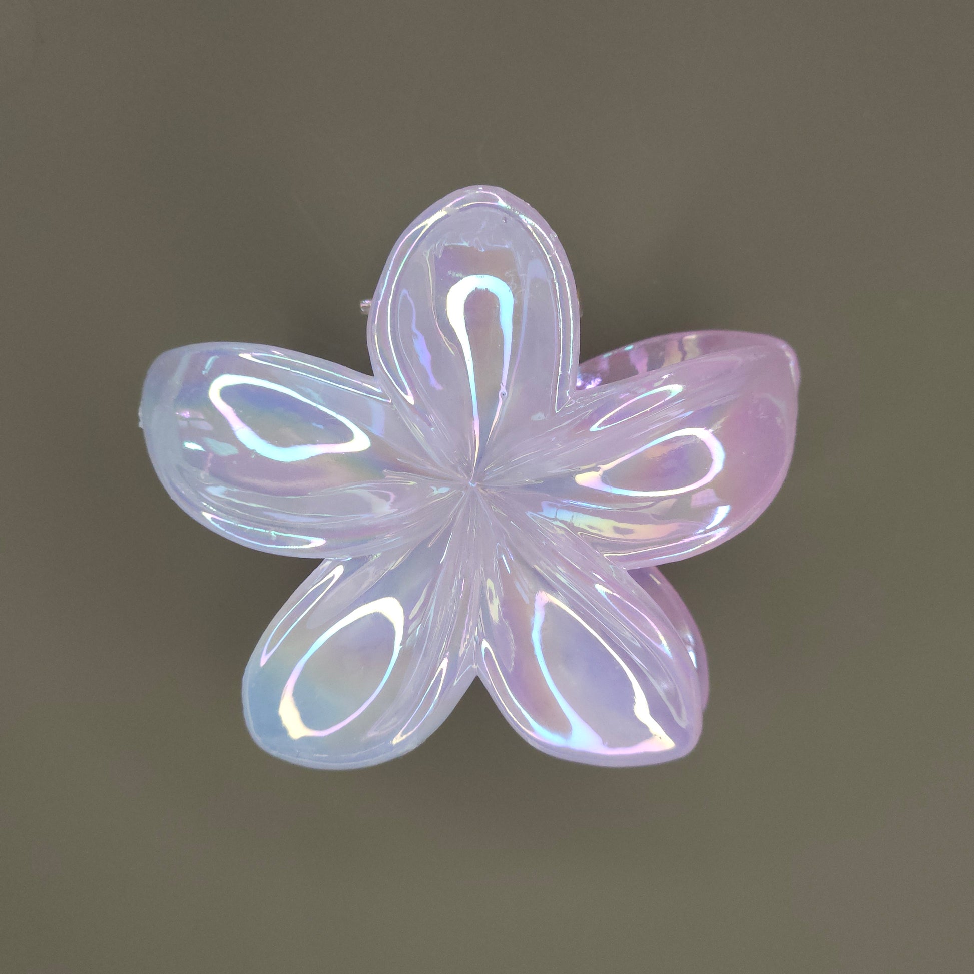A medium-sized, flower-shaped hair claw clip made of a white material with a 'dual shade glimmer' finish, creating subtle iridescent shifts or a pearlescent effect, possibly hinting at soft pastel undertones.