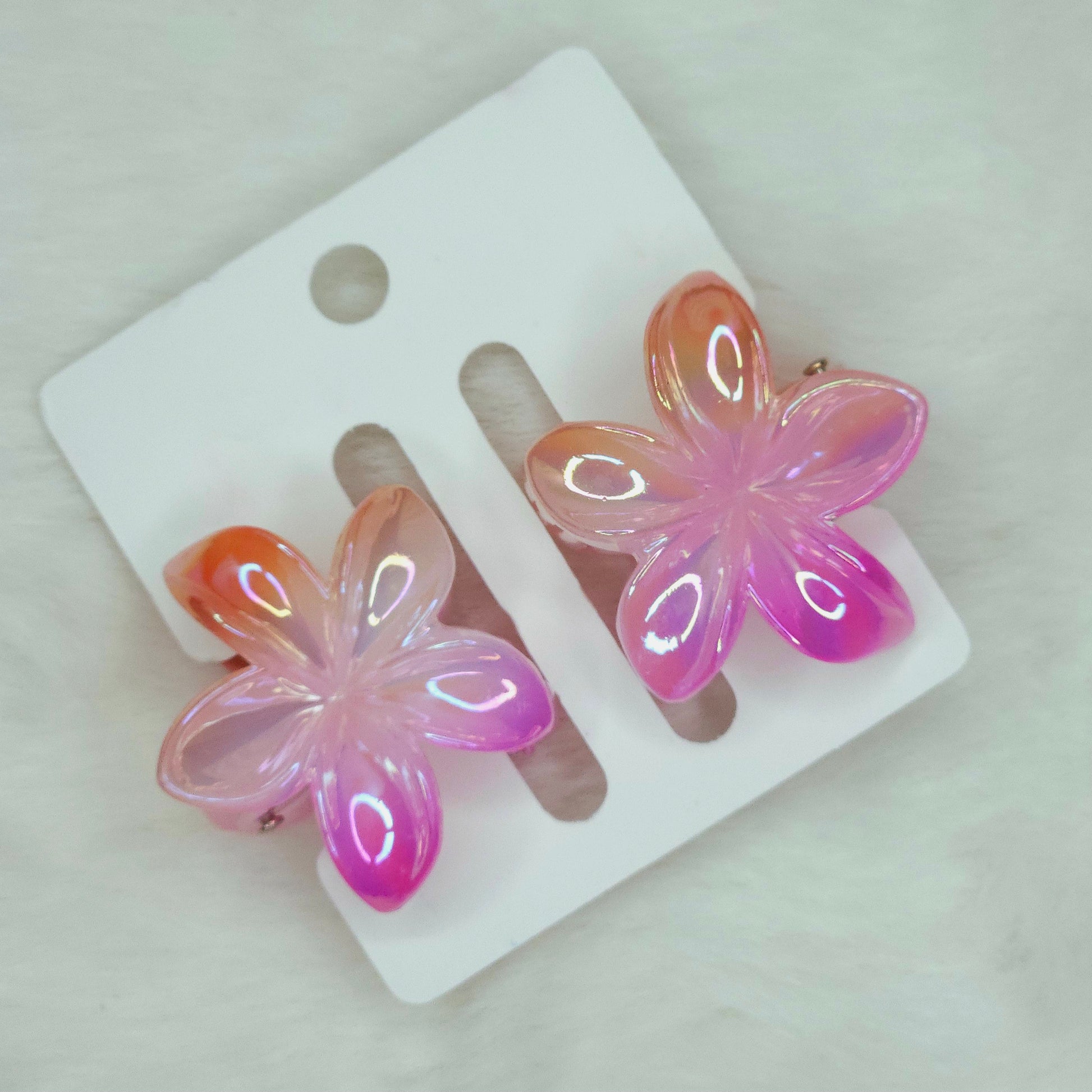 Close-up of dual-shade orange-pink lower hair claw showing detailed petal texture and color gradient.