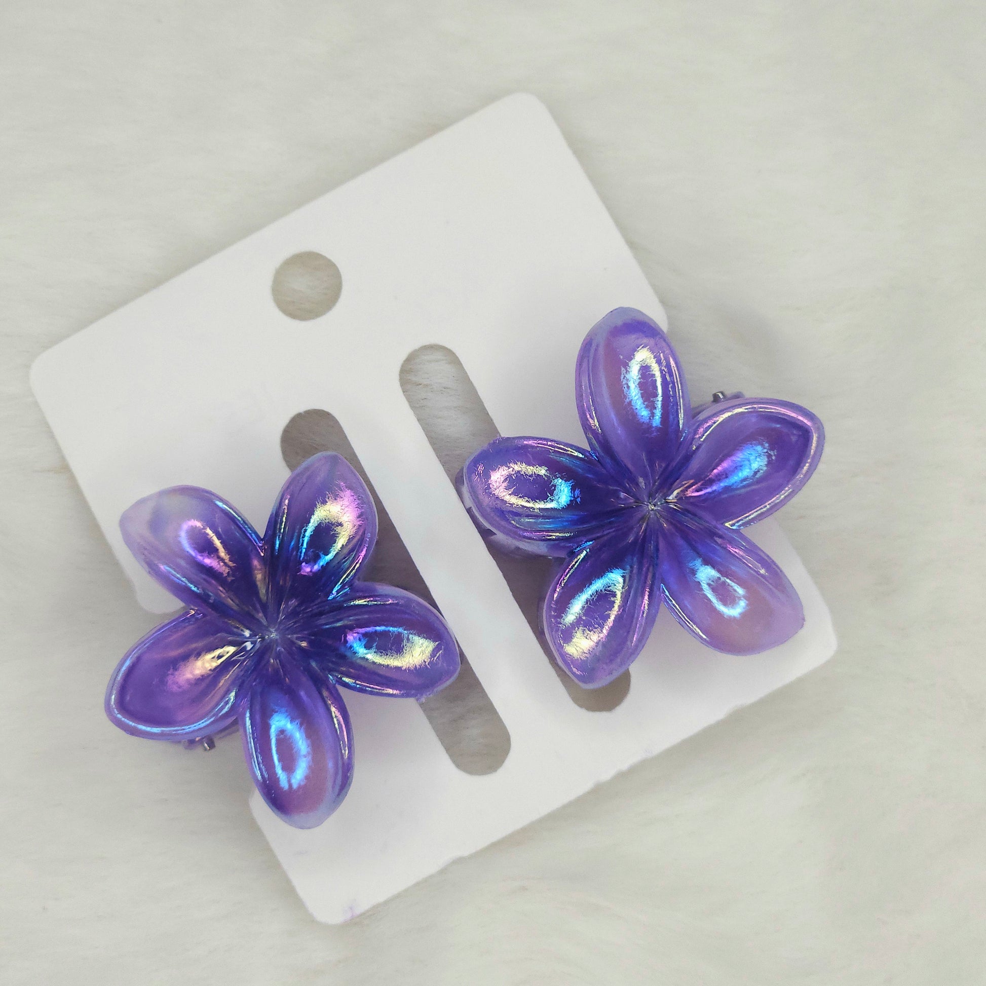 Pair of shiny dual-shade purple mini flower hair claws with iridescent finish, displayed on a white background card.