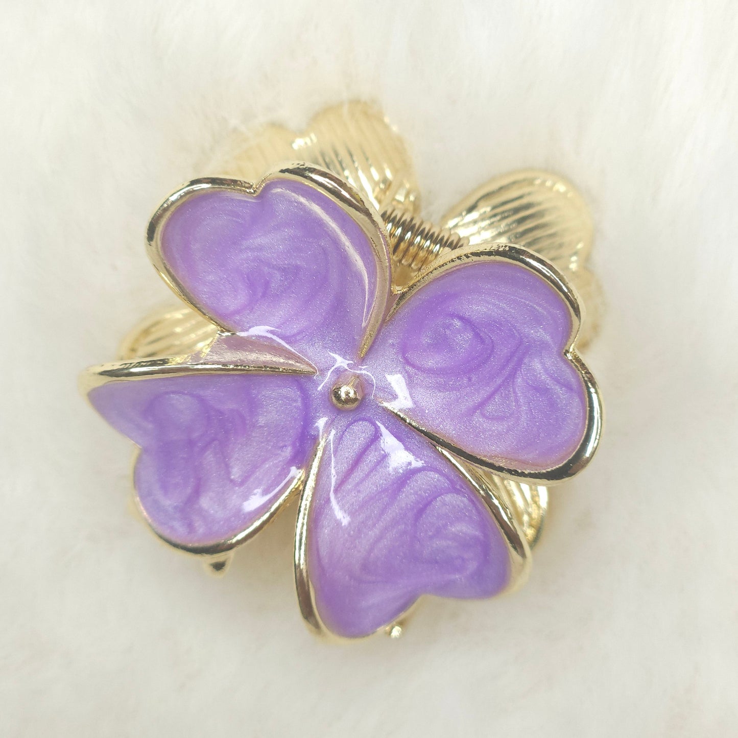 Purple butterfly-shaped hair claw with gold accents on a white background