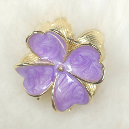 Purple butterfly-shaped hair claw with gold accents on a white background