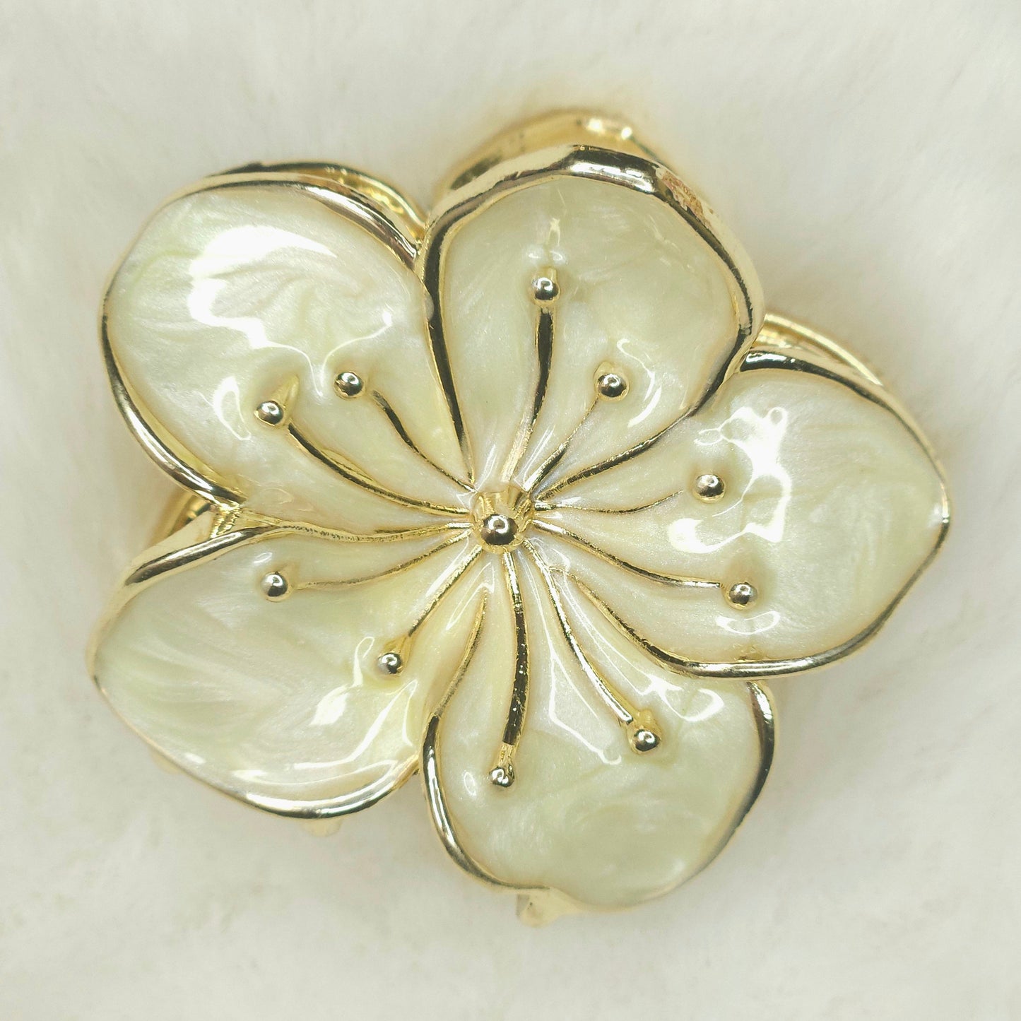 Floral hair claw with gold and silver accents on a light background