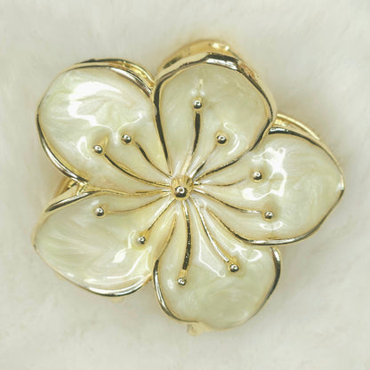 Floral hair claw with gold and silver accents on a light background
