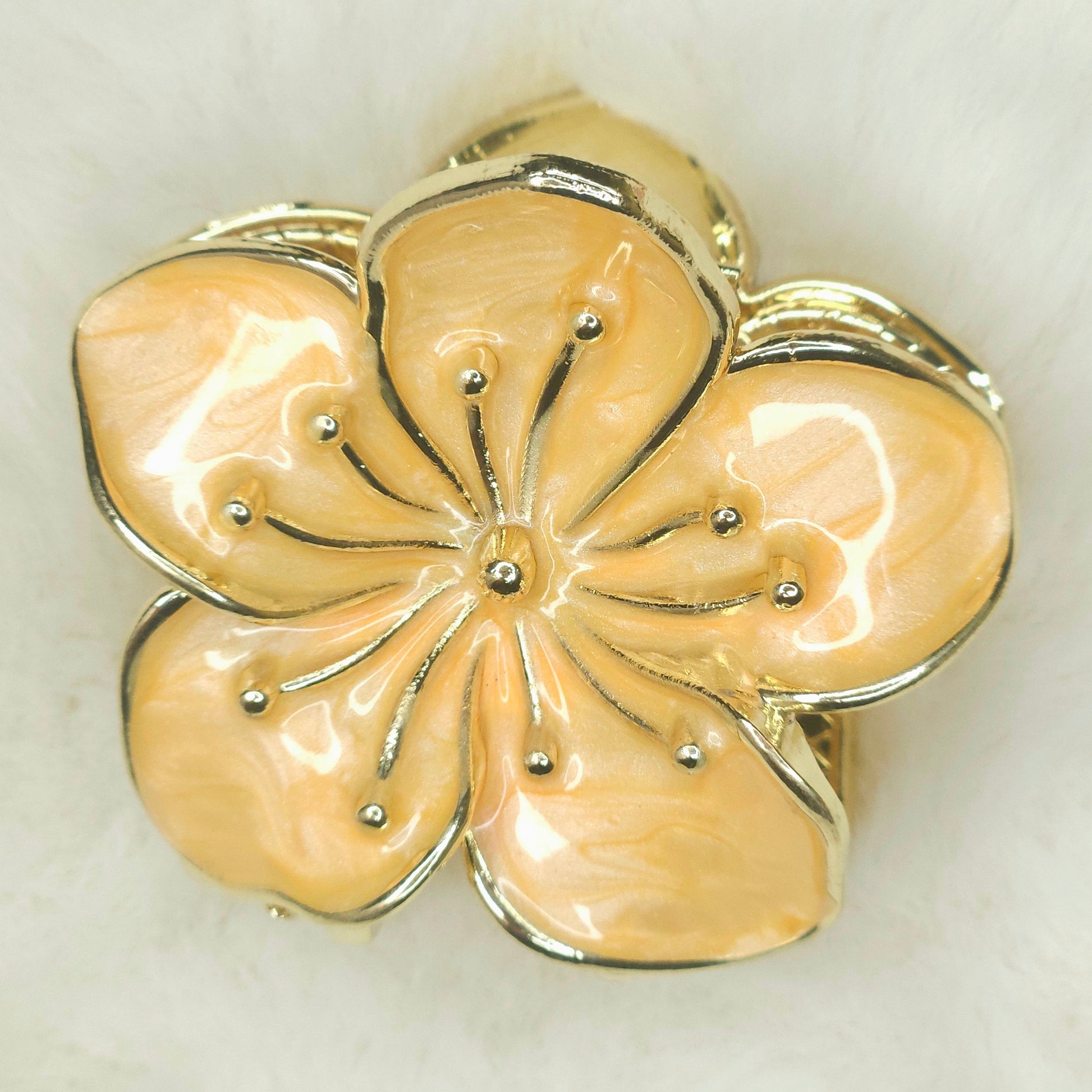 Floral-shaped hair claw with gold accents on a white background