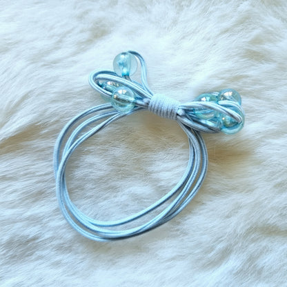 Clear plastic hair tie on a white fur background