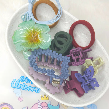 Assorted colorful hair accessories on a white plate with a 'Unicorn' branded background.