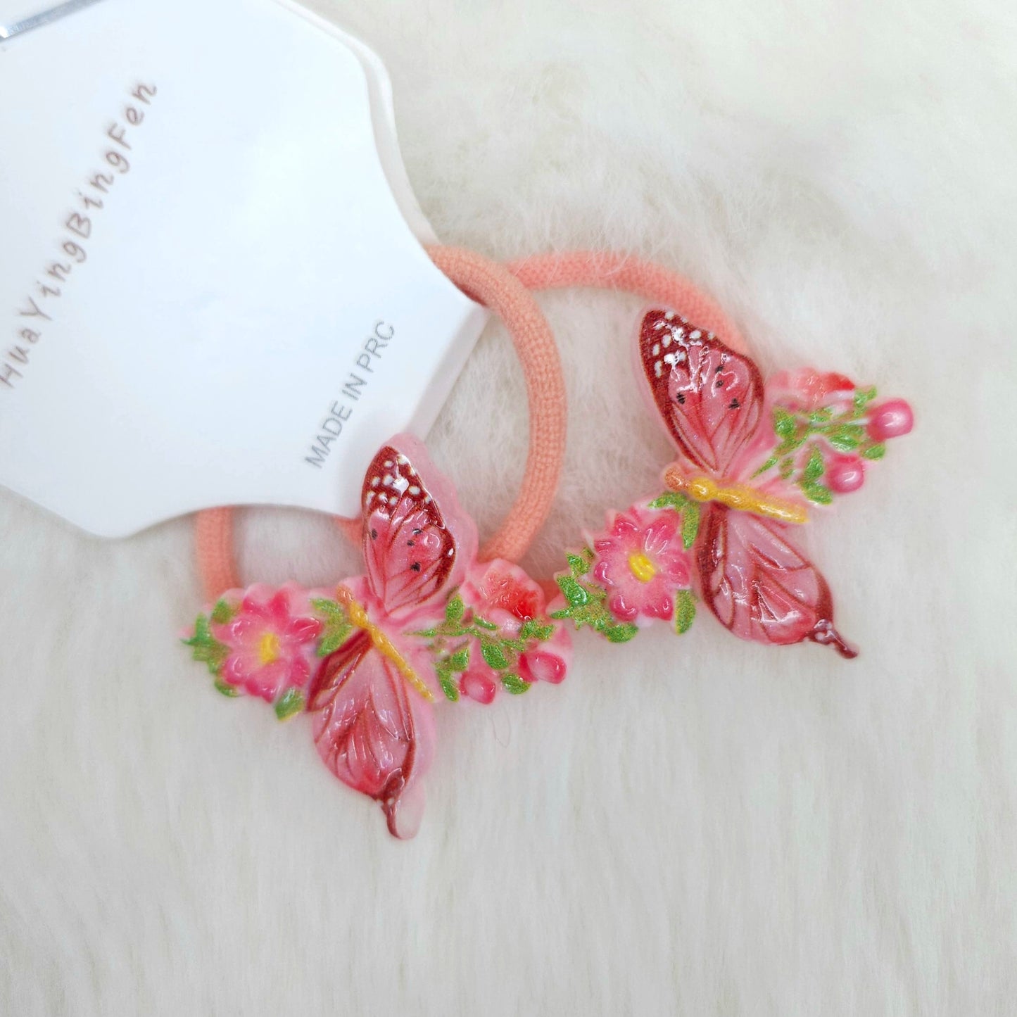 Hair tie with butterfly and flower design hair ties on a white background