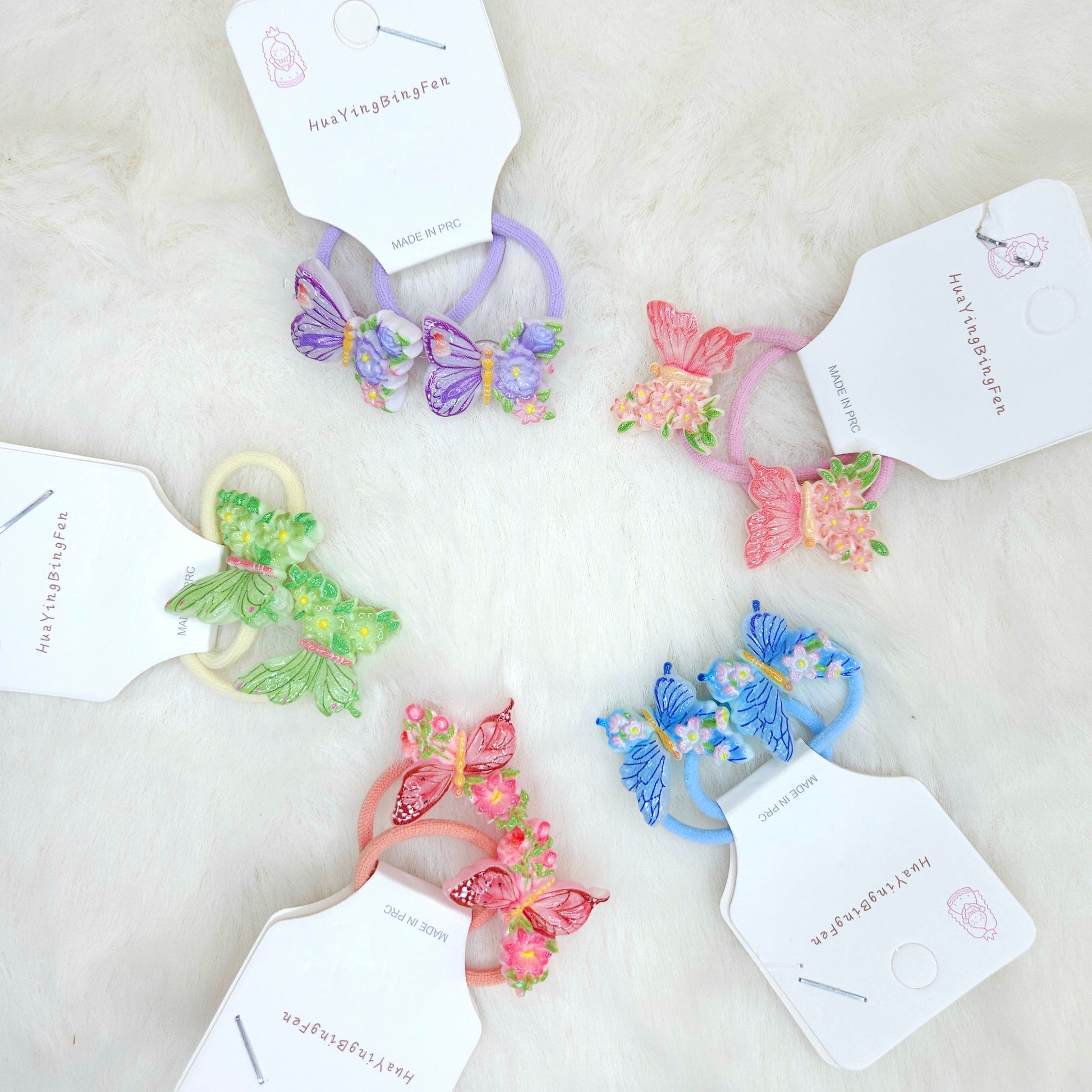 Colorful butterfly-themed hair ties with tags on a light background