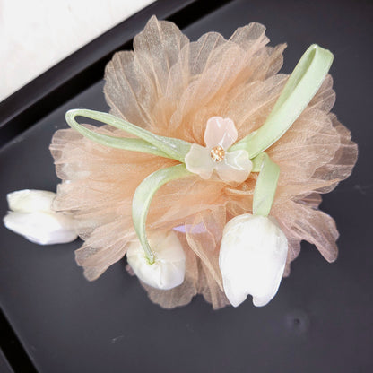 Decorative hair clip with floral elements on a black surface