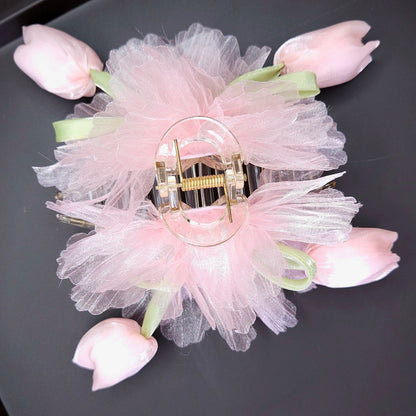 Decorative hair clip with pink flowers on a black tray