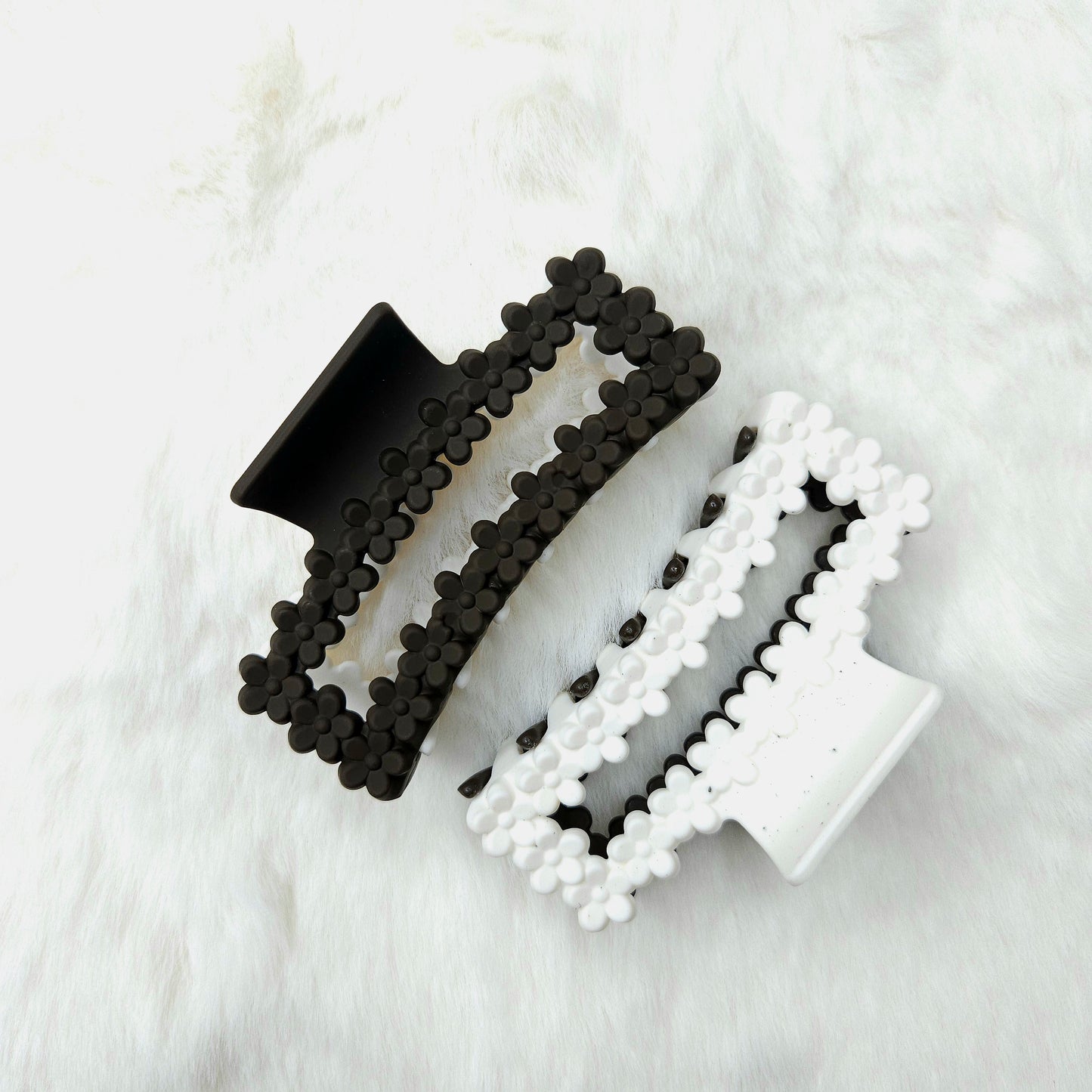 Brown and white hair claw clips on a textured white surface