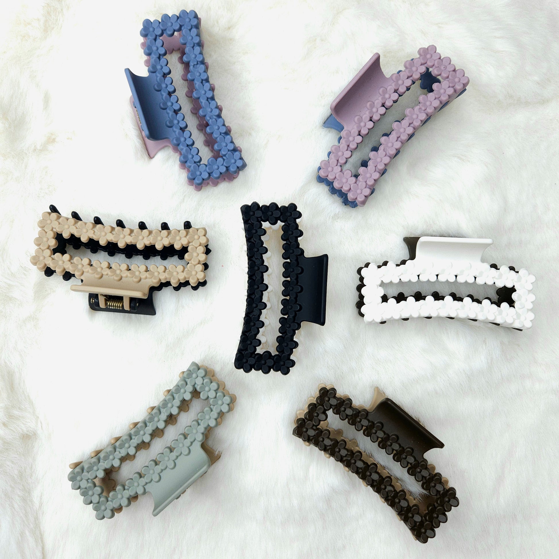 Set of rectangular shaped colorful hair clips with floral details on a white background