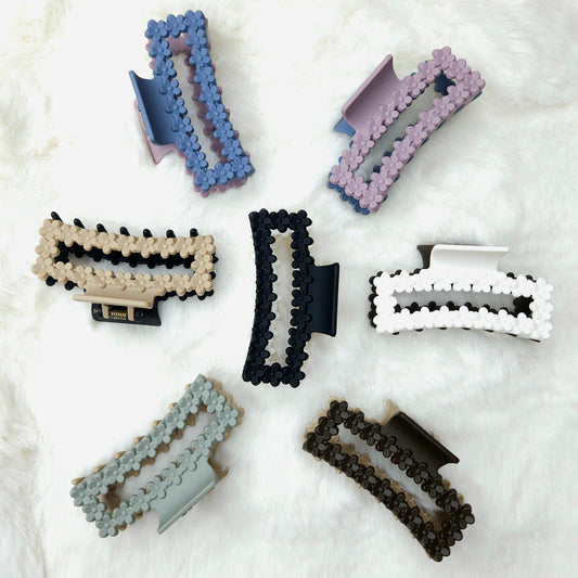 Set of rectangular shaped colorful hair clips with floral details on a white background