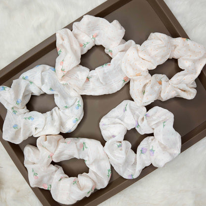 White scrunchies with floral patterns on a brown tray