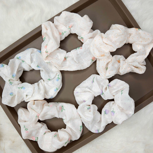 White scrunchies with floral patterns on a brown tray