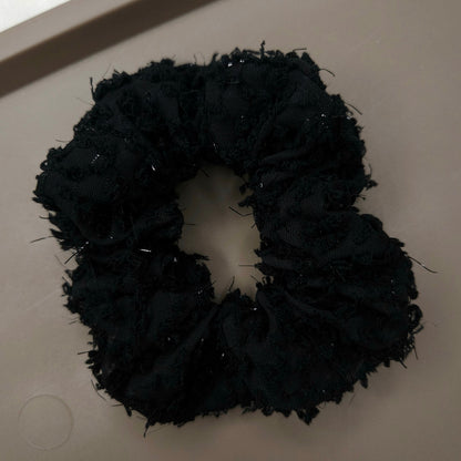 Black scrunchie on a light gray background