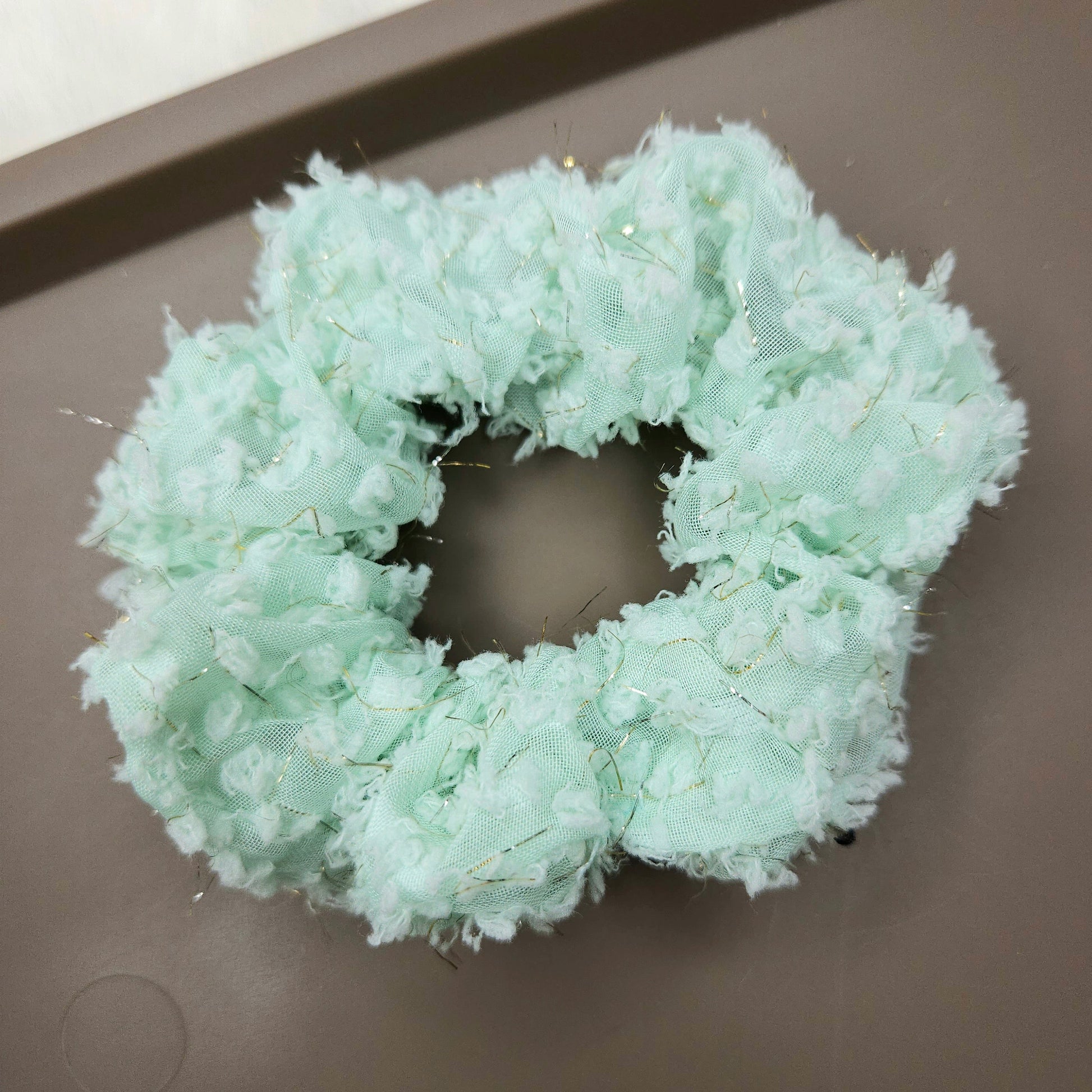 Light green scrunchie on a dark surface