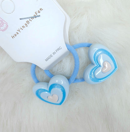 Heart-shaped hair ties with blue accents on a white background