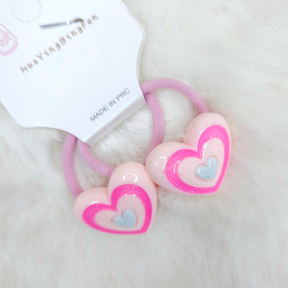 Heart-shaped hair ties with pink and hair ties on a white background