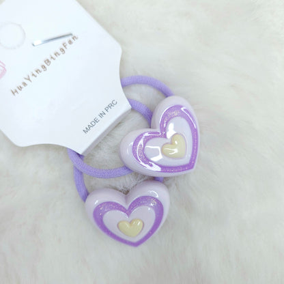 Heart-shaped hair ties with a white label on a light background