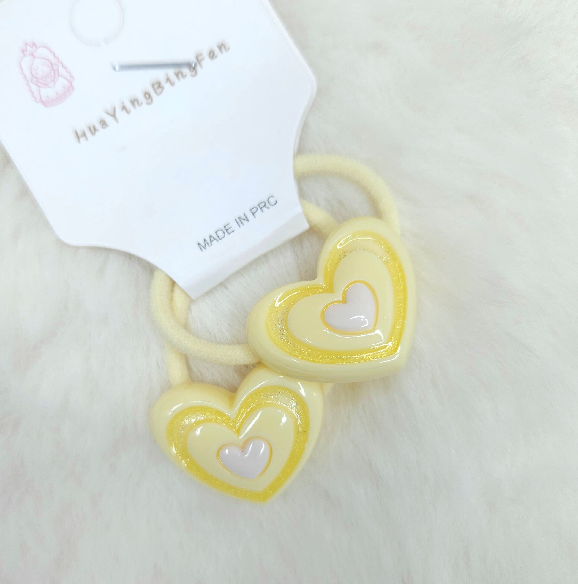 Heart-shaped hair ties with a visible brand label on a light background