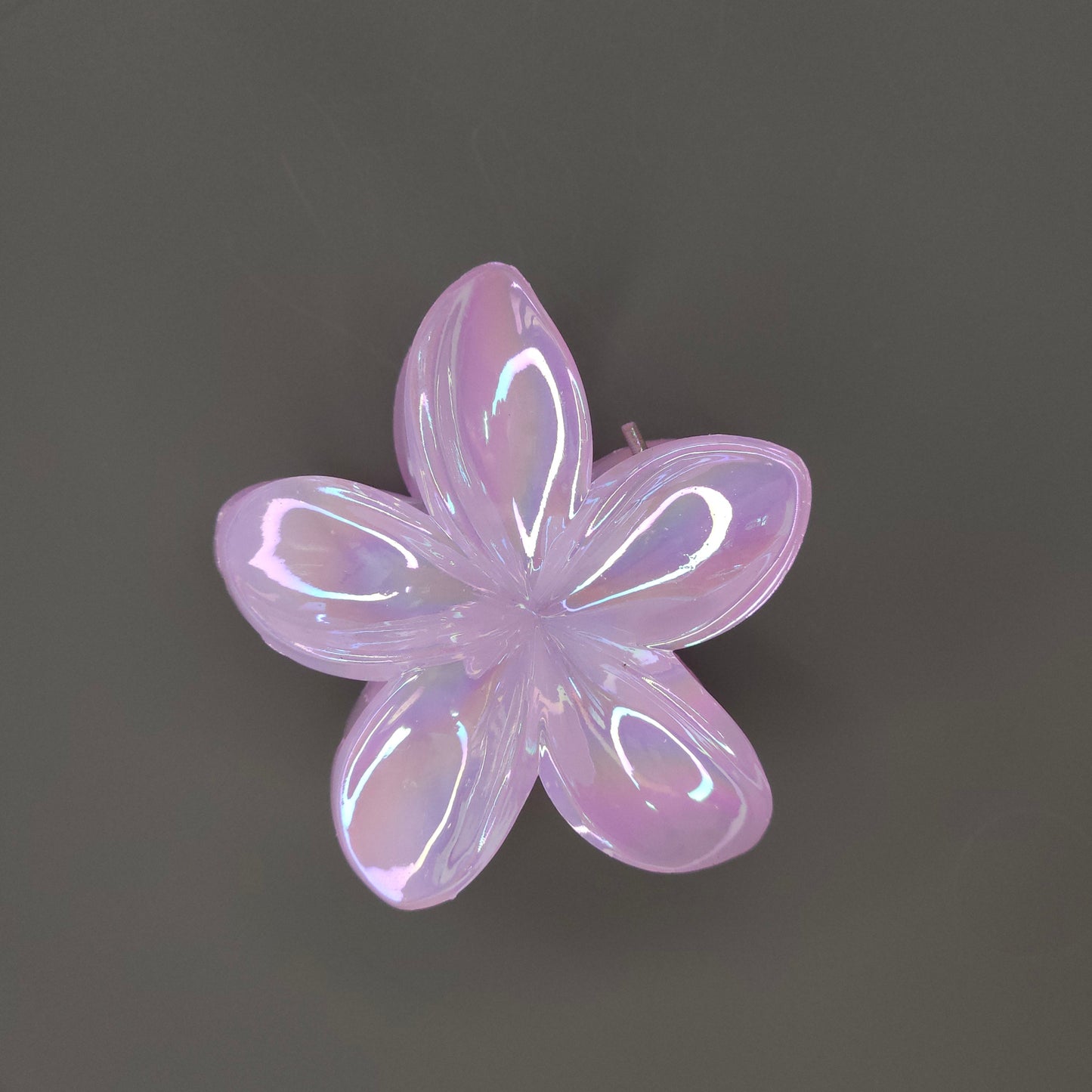 A single medium-sized, glossy pink flower hair claw clip with a shimmering, iridescent finish, designed with layered petals.