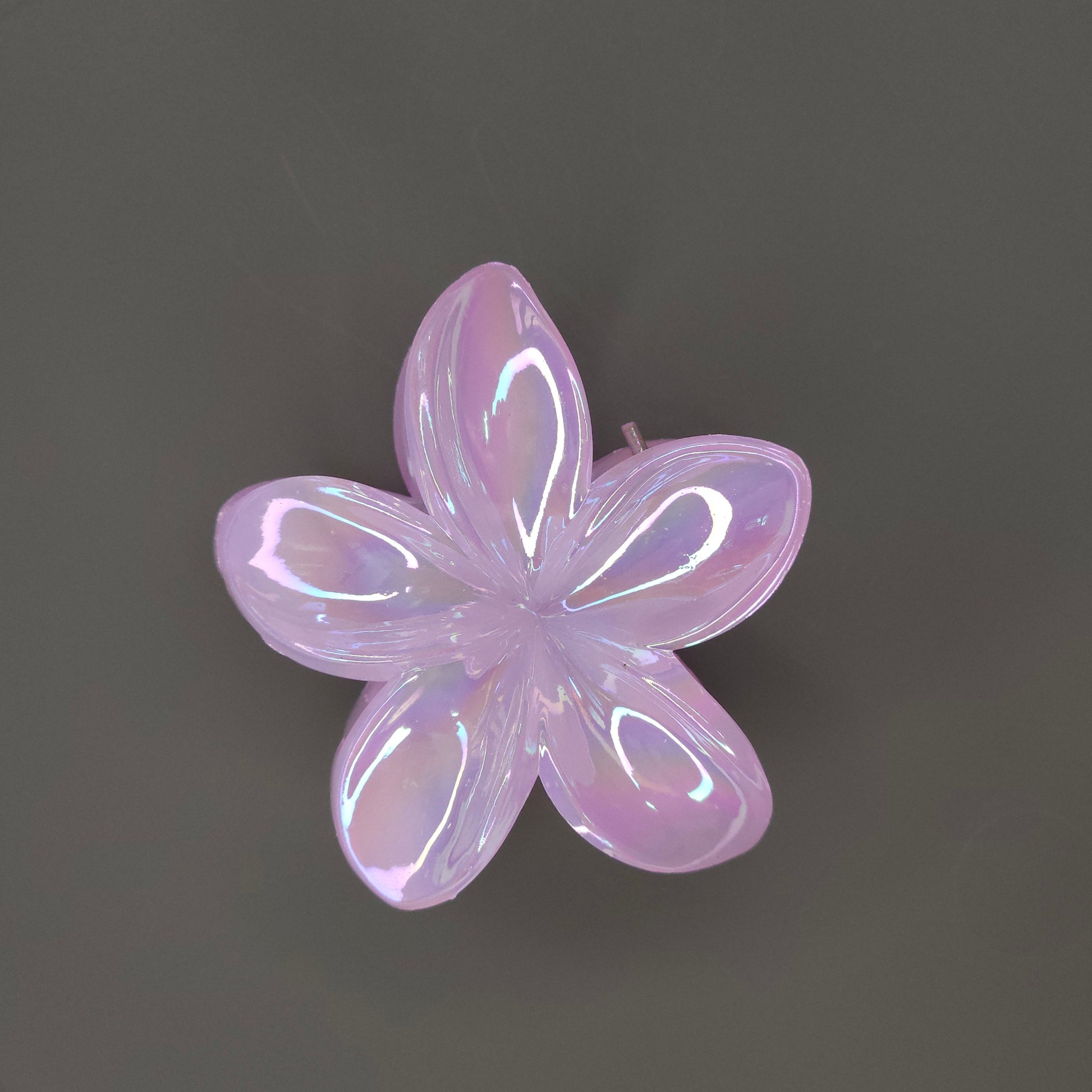 A single medium-sized, glossy pink flower hair claw clip with a shimmering, iridescent finish, designed with layered petals.