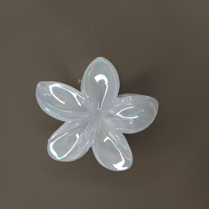 A single medium-sized, white flower-shaped hair claw clip with a subtle glimmering or iridescent finish, designed with delicate, overlapping petals.