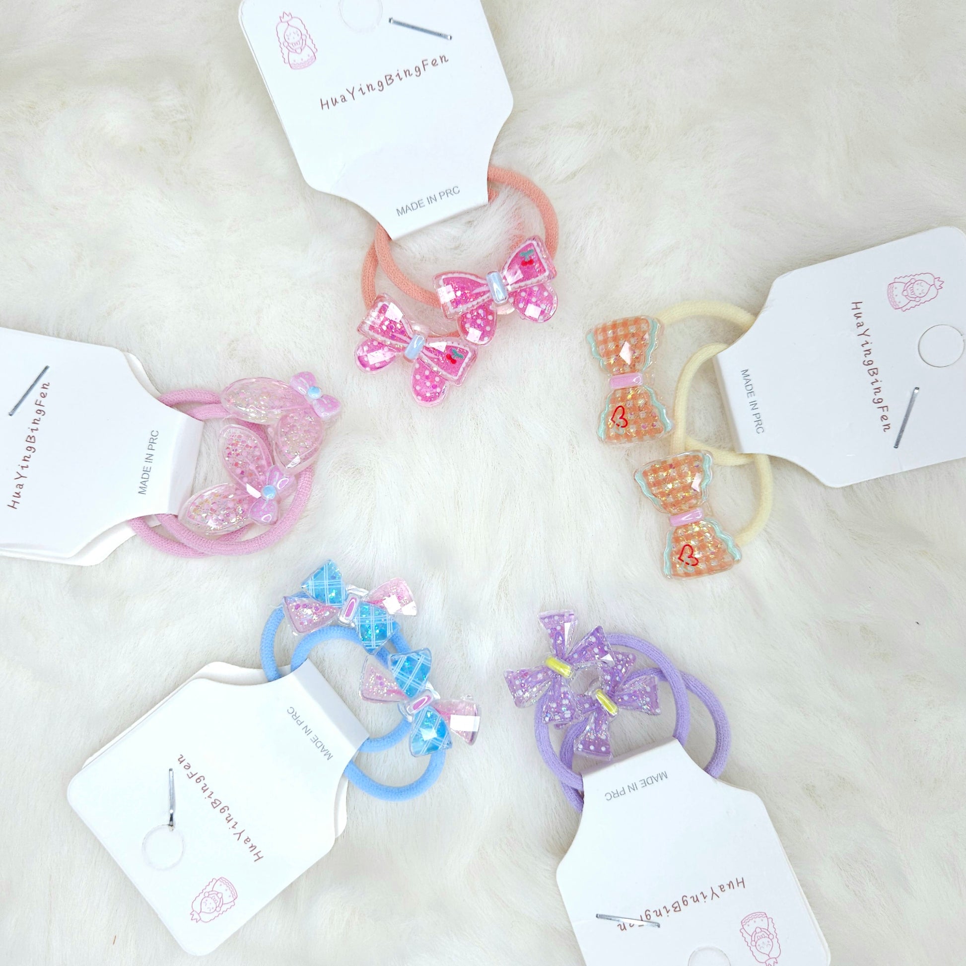 Set of colorful hair ties with decorative bows on a light background