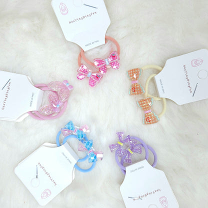 Set of colorful hair ties with decorative bows on a light background