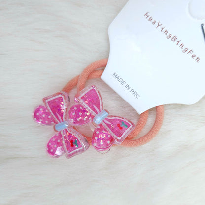 Pink butterfly hair accessories with a visible brand label on a light background