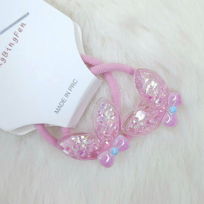 Pink hair tie with glittery bows on a white background