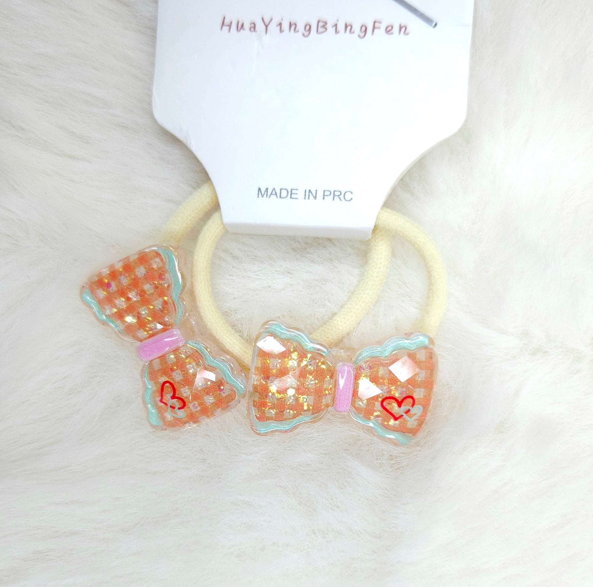 Two decorative hair ties with bow designs on a white background, branded 'HuayiBingFen'.