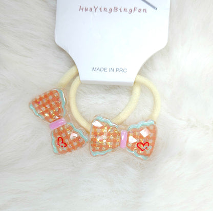 Two decorative hair ties with bow designs on a white background, branded 'HuayiBingFen'.