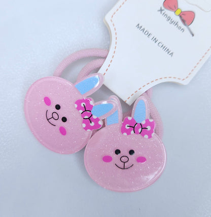 Two pink bunny-shaped hair ties with a tag on a light gray background