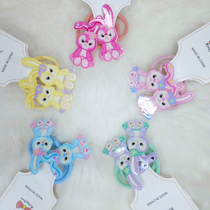 Set of colorful bunny-shaped hair ties on white background