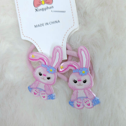 Two pink bunny-shaped hair ties with a tag labeled 'Xingyihan' on a white background.
