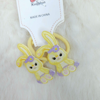 Two yellow bunny-shaped hair ties with purple accents on a white background, branded 'Xingyishan'.