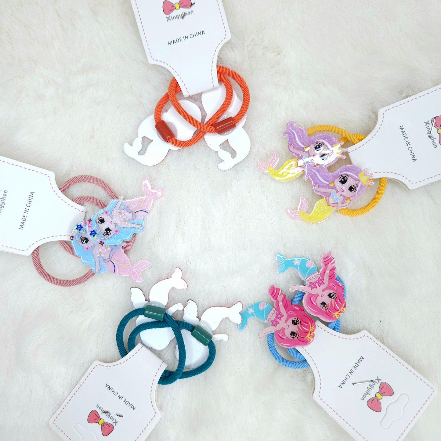 Colorful hair ties with cartoon character tags on a white background