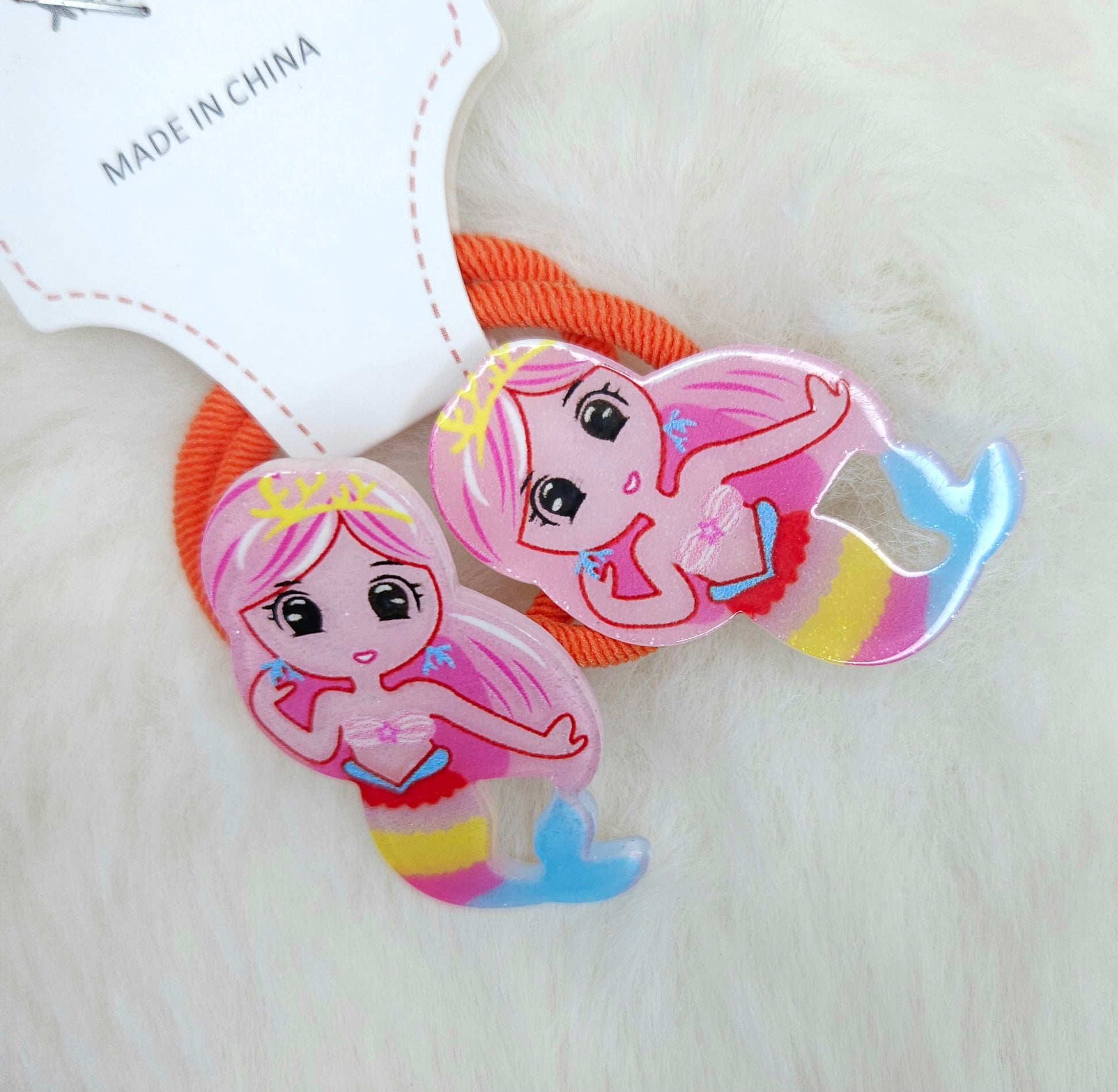 Two mermaid-themed hair ties on a white background with 'Made in China' label.