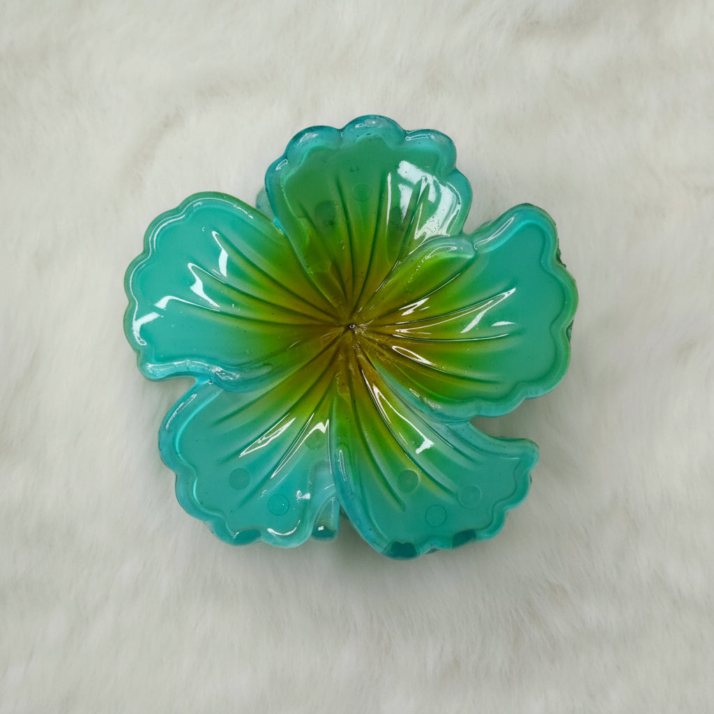Green hibiscus flower-shaped hair claw on a white background