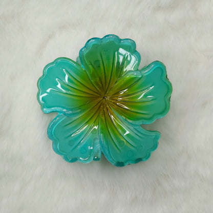 Green hibiscus flower-shaped hair claw on a white background