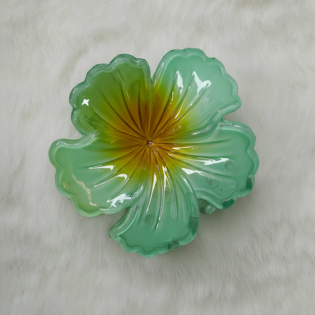 Green glass flower-shaped object on a light gray background