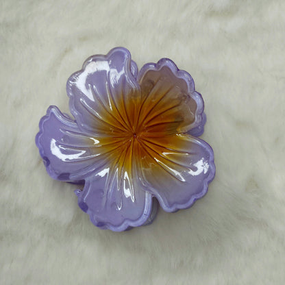 Hibiscus Floral-shaped hair claw clip with purple and yellow colors on a white background