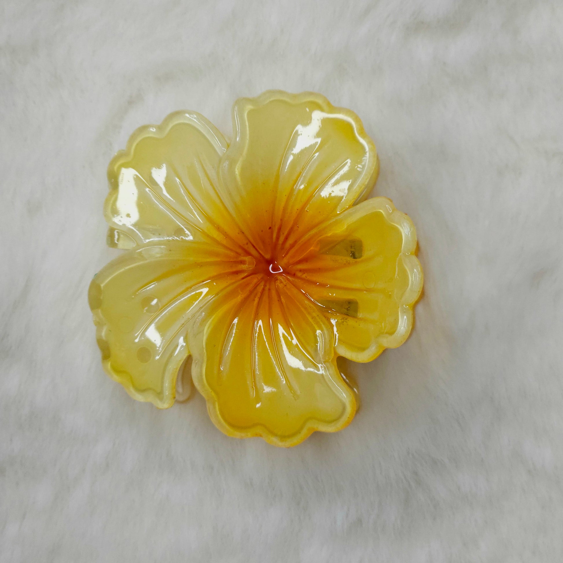 Yellow color hibiscus flower-shaped hair claw on a white background